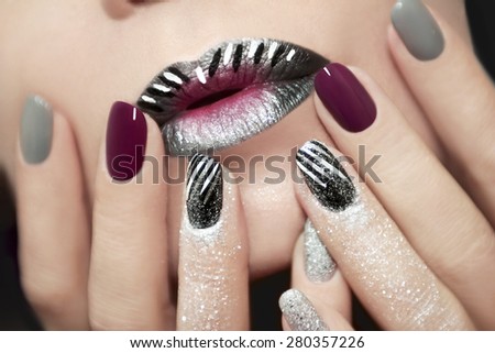 Design with white and black stripes on the lips and nails with glitter.
