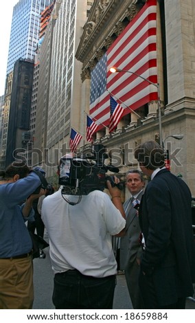 NEW YORK, NY -- OCTOBER 9, 2008: A news reporter interviews a stock trader outside of the New York Stock Exchange on October 9, 2008, the day the NYSE suffered its second greatest point drop ever.