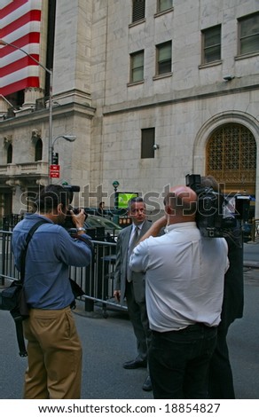 NEW YORK, NY -- OCTOBER 9, 2008: A news reporter interviews a stock trader outside of the New York Stock Exchange on October 9, 2008, the day the NYSE suffered its second greatest point drop ever