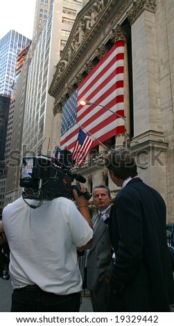 NEW YORK, NY -- OCTOBER 9, 2008: A news reporter interviews a stock trader outside of the New York Stock Exchange on October 9, 2008, the day the NYSE suffered its second greatest point drop ever