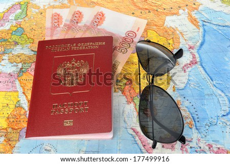 Sunglasses and Russian international passport with money on the world map