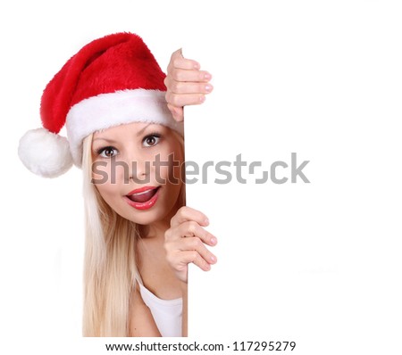 surprised young woman in Santa hat holding white board with space for text isolated on white