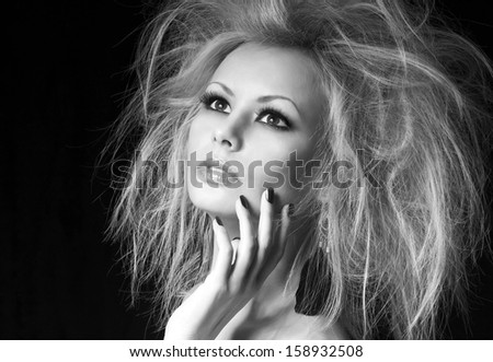 Fashion blonde girl. Beautiful woman with professional makeup and humidity hair style, over black background. Vogue model. Black and white