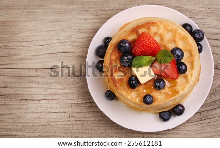 Waffles with Strawberry and Blueberry over wooden background