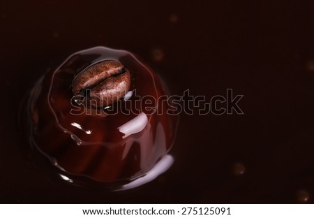 Coffee bean on malted chocolate. Liquid chocolate