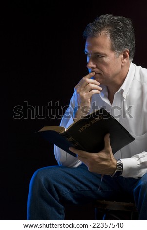 A Man Sitting In A Dark Room Contemplating His Bible Reading, Side Lit ...