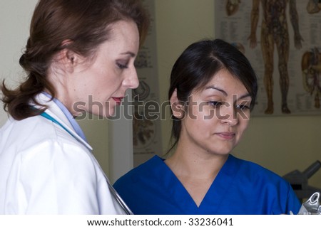 A doctor and a nurse looking over a patient\'s chart.