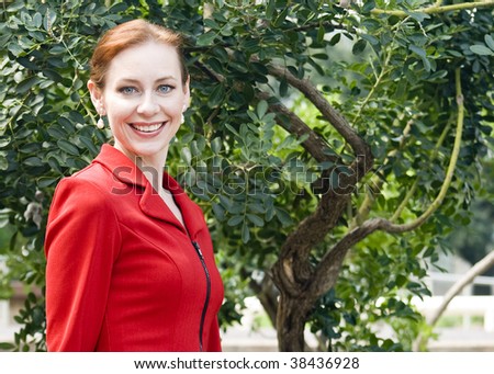 A lovely redhead with beautiful blue eyes smiles big for the camera.