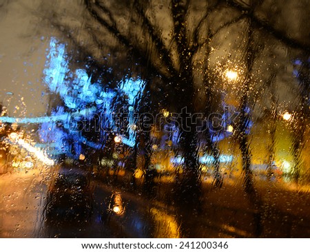 Wet the car window with the background of the night city lights