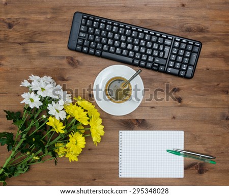 computer Keyboard, cup coffee and flower on old wooden table