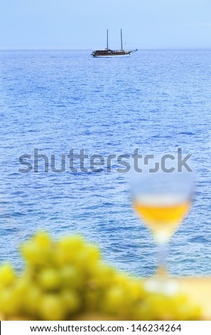Beautiful relaxing sea view with glass of wine and fresh grape.