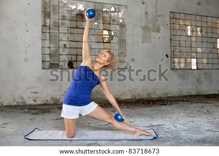 Pilates exercise / Beautiful blond woman exercises with a fitness balls in an abandoned house