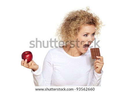 Healthy or unhealthy food? / Beautiful blond woman chooses to eat chocolate instead of red apple