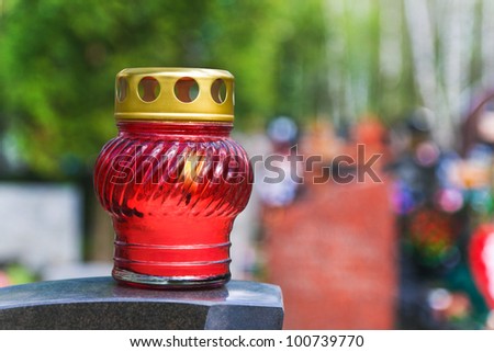 Candle on stone tomb at cemetery - religion background