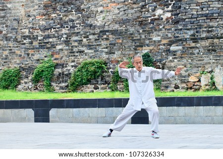 XIANG YANG-CHINA-JULY 4, 2012. Old man practice Tai Chi on July 4, 2012 in Xiang Yang. Tai Chi Chuan means Supreme Ultimate Fist, it is a martial art practiced both for self defense and health.