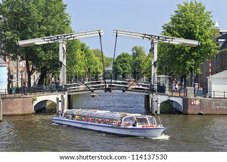 AMSTERDAM-AUG. 19:Tour-boat on Aug. 19, 2012 in Amsterdam. It is known as Venice of the North. The city has 1,200 bridges and 165 canals. Best way to experience them is one of the boat tours.