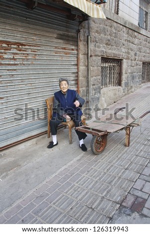 QINGDAO-CHINA-NOV. 4. Female elderly outside on a chair. The population of China\'s elderly (60 or older) is about 128 million or one in every ten people, the world\'s largest. Qingdao, Nov. 4, 2006.