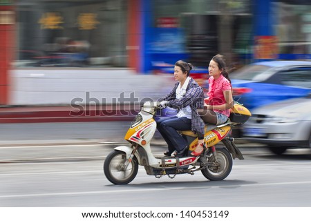 SHANGHAI-MAY 28. Two girls riding on an e-bike. Two- and three-wheeler e-bikes account for more than half of all lead consumption in China and 20 percent of global demand. Shanghai, May 28, 2013.