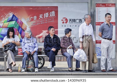 SHANGHAI-JUNE 3. Chinese elderly at bus stop. China\'s elderly surpasses 200 million in 2014, top 300 million by 2025. By 2042, more than 30% of China\'s population ages over 60. Shanghai, June 3, 2013.