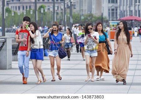 SHANGHAI-JUNE 6. People walking at the Bund. The Bund has dozens of historical buildings, lining the Huangpu River, once housed numerous Western banks and trading houses. Shanghai, June 6, 2013.