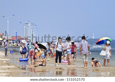 YANTAI-CHINA-JULY 24. Beach packed with people seeking coolness. Because of its fair weather, extensive coasts and many tourist sites Yantai is a very popular summer retreat. Yantai, July 24, 2013.