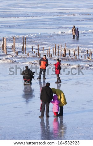 HARBIN-MARCH 7. City dwellers enjoy frozen Songhua River. Harbin is located Northeast China under influence of cold Siberia winter wind. Average temperature winter is -??16.8 Ã?Â°C. Harbin, March 7, 2009