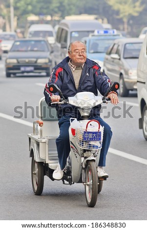TIANJIN-OCTOBER 13, 2008. Chinese elderly on a Dalian e-bike. Motorized bikes in Chinese cities became a rarity, the number of electric-powered bicycles in China just passed the 200 million mark.