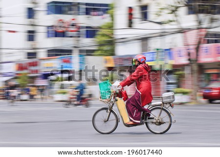 SHANGHAI-MAY 3, 2014. Woman on electric bike. In just a decade, Chinese e-bikes increase from near zero to over 150 million, the largest adoption of an alternative fuel vehicle in motorization history