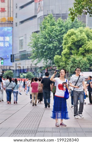 SHANGHAI-JUNE 5, 2014. Chinese woman takes a photo with a Canon Power-shot camera. The Power-Shot line has been successful for Canon, and is one of the best-selling digital camera lines worldwide.