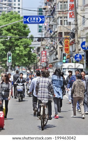 SHANGHAI-MAY 5, 2014. City dwellers on the street in a dense area. Urban densities average around 40,000 residents per square KM in core districts, 760 persons per hectare in Huangpu central area.