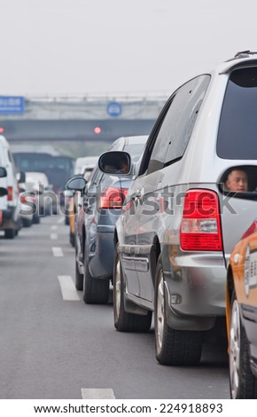 BEIJING-OCT. 19, 2014. Traffic jam in smog covered city. Beijing suffered severe air pollution which is mainly caused by exhaust emission of five million cars and coal burning in neighboring regions.