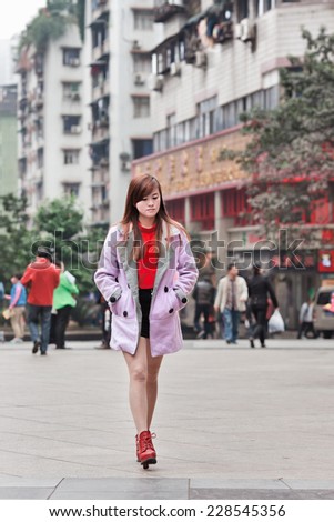 CHONGQING-NOV. 4, 2014. Trendy girl in shopping area. According a research, Chinese consumers under the age of 28 have zero savings because they spend everything on clothes and consumer electronics.