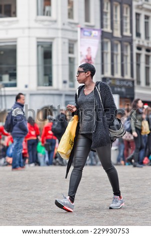 AMSTERDAM-AUGUST 26, 2014. Surinam girl walk at Dam Square. According to the Amsterdam city council, 177 different nationalities residing in the Dutch capital, the world\'s most multicultural city.