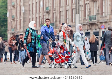 AMSTERDAM-AUGUST 26, 2014. Muslim family walk on the Dam Square. There are an estimated 1.2 million Muslims in the Netherlands, which is equivalent to about 6 percent of the country\'s population.
