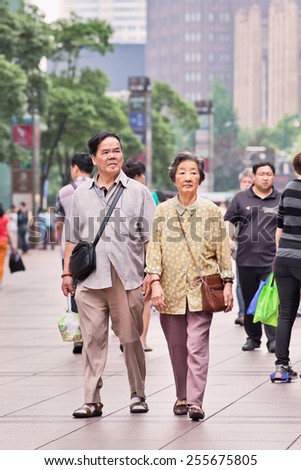 SHANGHAI-JULY 4, 2014. Elderly couple walk in city center. The population of the elderly (60 or older) in China is about 128 million, one in every ten people, which is the largest in the world.