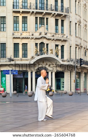 SHANGHAI-MAY 6, 2014. Traditional dressed man practicing Tai Chi in the early morning. Tai Chi Chuan means Supreme Ultimate Fist, it is a martial art practiced both for self-defense and health.