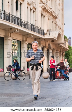 SHANGHAI-MAY 6, 2014. Old Chinese man jogging in early morning. It is surprising that few of Chinese exercised seriously before retiring. Commonly, their athletic exercise begins when they are old.