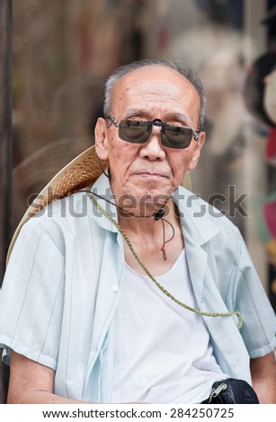 BEIJING-JUNE 1, 2015. Old man with sunglasses. Elderly population (60 or older) in China is about 128 million, one in every ten people, the world\'s largest. China will have 400 million elderly by 2050