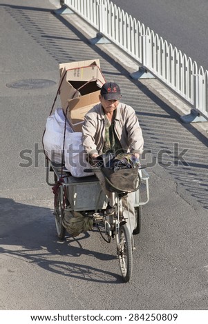 BEIJING-OCTOBER 17, 2011. 2010. Man with cargo bike on the road. Although their number is declining, cargo bikes or freight tricycles are still a popular transportation mode in major Chinese cities.