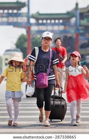 BEIJING-JUNE 9, 2015. Young woman with two daughters. Although China has relaxed its one-child policy late 2013, the number of Chinese families having more than one child is still relatively low.