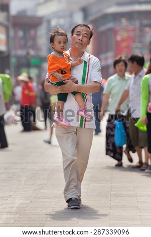BEIJING-JUNE 9, 2015. Chinese father with child. China\'s one-child policy, initiated late 1970s - early 1980s was to limit families have one child to reduce growth rate of China\'s enormous population.