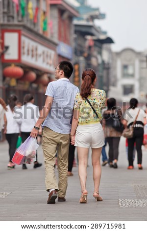 BEIJING, CHINA -JUNE 9, 2015. Young couple in city center. For decades, most urban Chinese families could have only one child. Now officials in China\'s capital asking young couples to have more children.