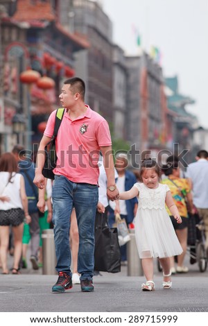 BEIJING, CHINA -JUNE 9, 2015. Chinese man with child. China\'s one-child policy, initiated late 1970s - early 1980s was to limit families have one child to reduce growth rate of China\'s enormous population.