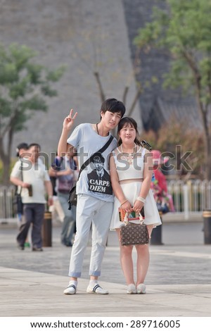 BEIJING, CHINA -JUNE 9, 2015. Young couple pose for photo. Chinese government considers to lower the minimum legal marriage age to 18. Currently minimum legal marriage age is 22 for males and 20 for females
