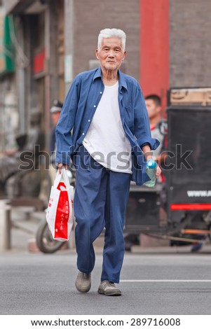 BEIJING, CHINA -JUNE 9, 2015. Handsome old man in city center. Elderly population (60 or older) in China is 128 million, one in every ten people, the world's largest. China has 400 million elderly by 2050.