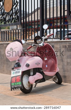 BEIJING, CHINA -JUNE 16, 2015. Pink Lvneng electric bike. Lvneng, established in 1999, is a Chinese manufacturer of electric vehicles which owns factories in Changzhou (South China) and Tianjin (North China).