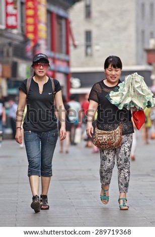 BEIJING, CHINA -JUNE 9, 2015. Middle aged woman in Beijing center. Lives of women in China have significantly changed after government made great efforts towards gender equality in a male-dominated society