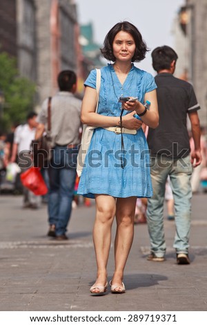 BEIJING, CHINA -JUNE 9, 2015. Young women walks in a shopping street. Lives of women in China have significantly changed after government made great efforts towards gender equality in a male-dominated society
