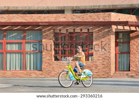 BEIJING-JULY 3, 2015. Young boy riding on a public share bike. Bicycle sharing allow to hire on a very short term basis, it is a very popular transport mode among commuters in major Chinese cities.