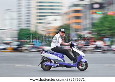 KUNMING-JULY 5, 2014. Man on an electric bike. An estimated 200 million Chinese now use e-bikes, 1,000-fold increase from 15 years ago. About 90 percent of world\'s e-bikes were sold in China in 2012.